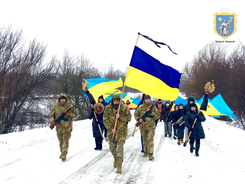 Військові несуть українські прапори взимку