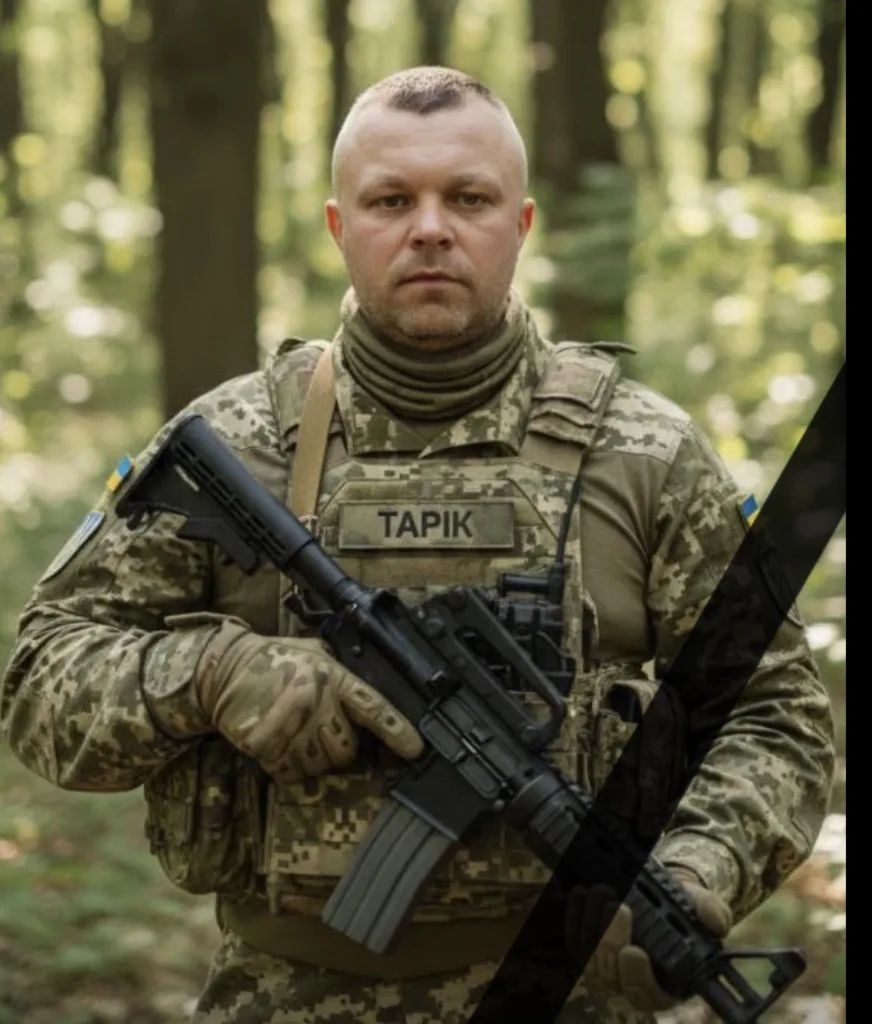 Український військовий у лісі тримає зброю