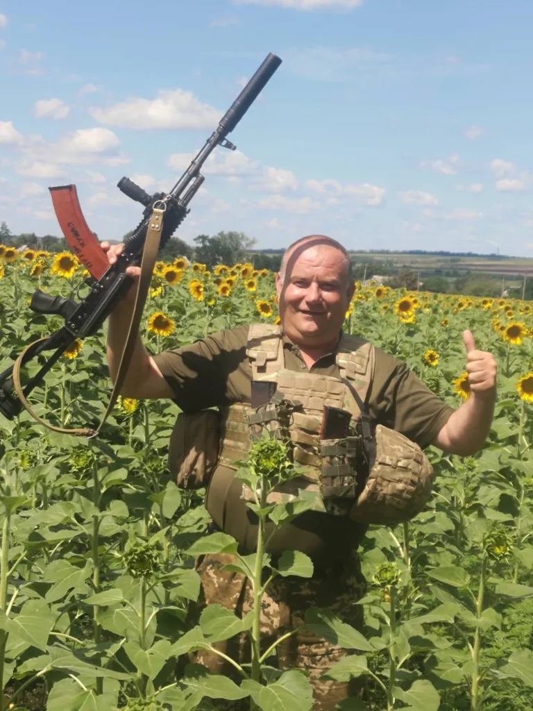 Військовий серед соняшників з піднятою зброєю