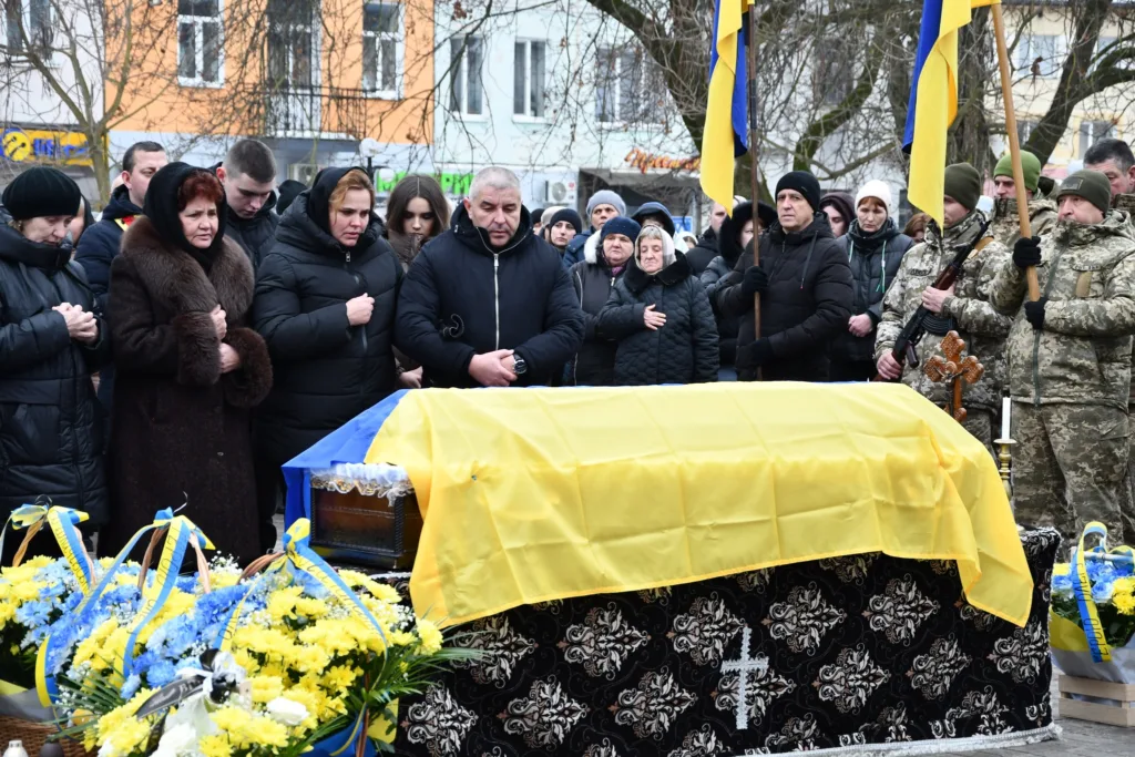 Похорон воїна з українським прапором та людьми