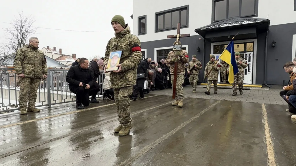 Військові несуть портрет і прапор України