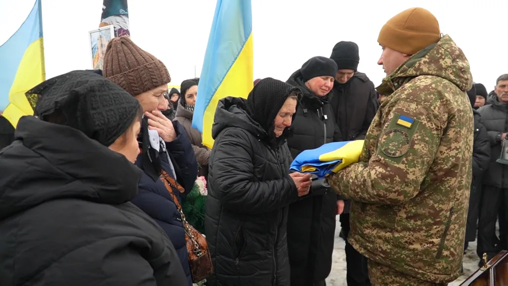 Військовий передає український прапор під час церемонії