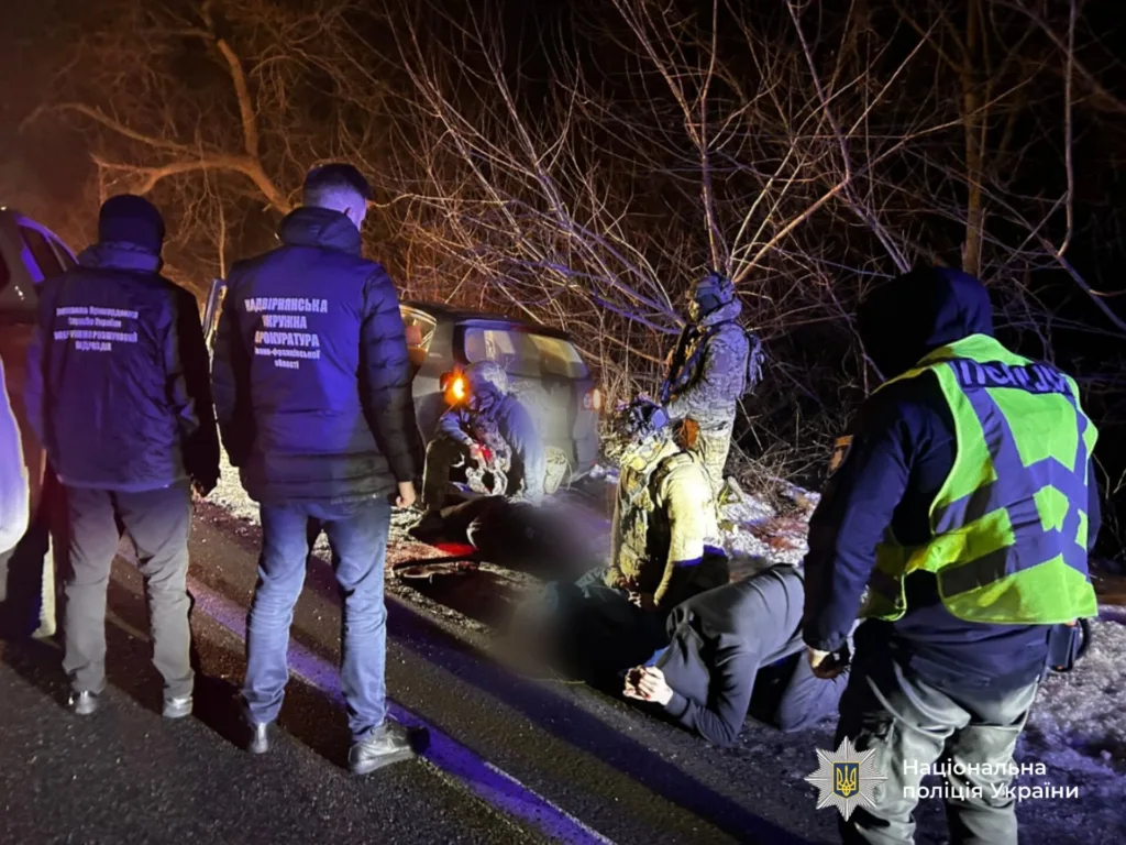 Поліція України затримує підозрюваних біля автомобіля вночі