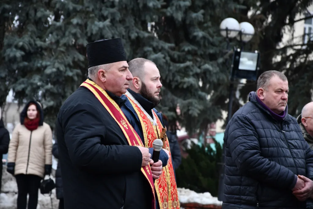 Священники та люди на вуличній церемонії взимку