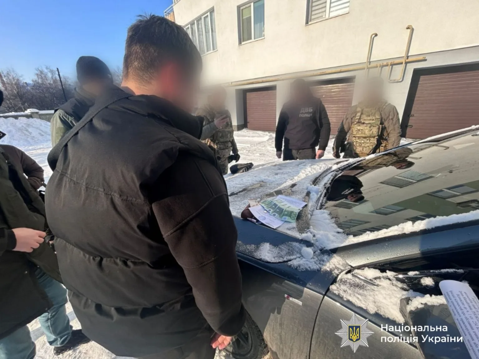 Поліція проводить обшук біля будинку взимку