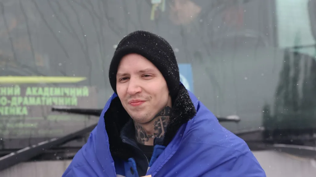 Чоловік у синій куртці під час снігопаду