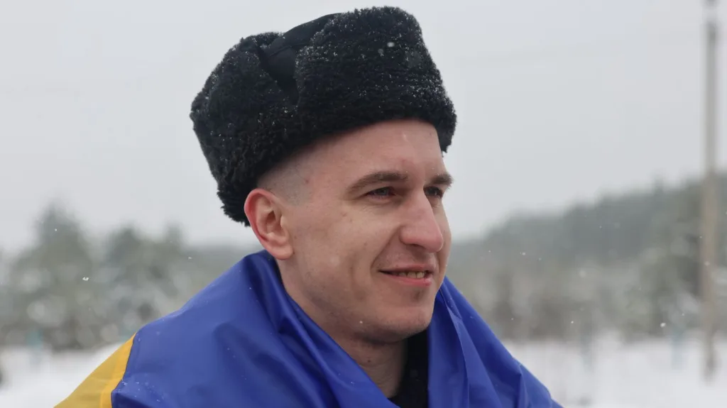 Чоловік у шапці з українським прапором на снігу