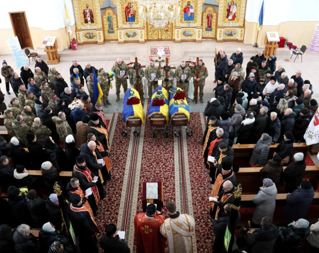Поховання українських військових у церкві з прапорами