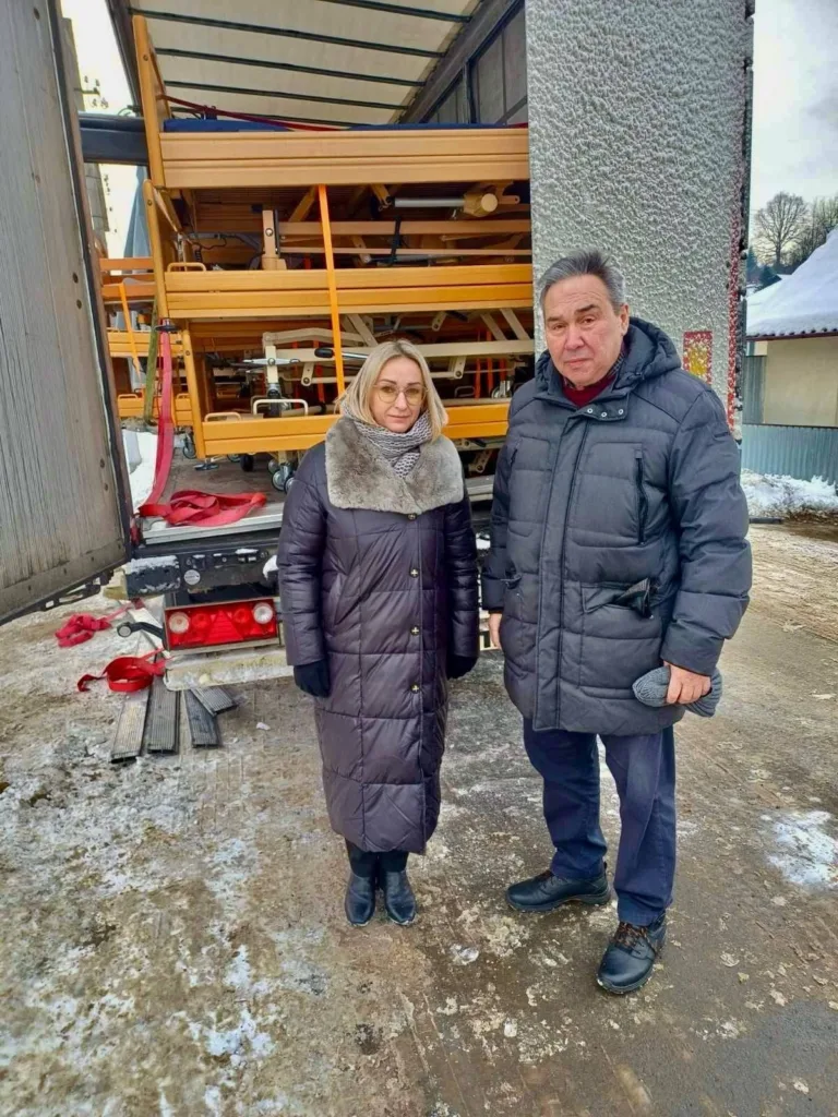 Двоє людей біля вантажівки з лікарняними ліжками