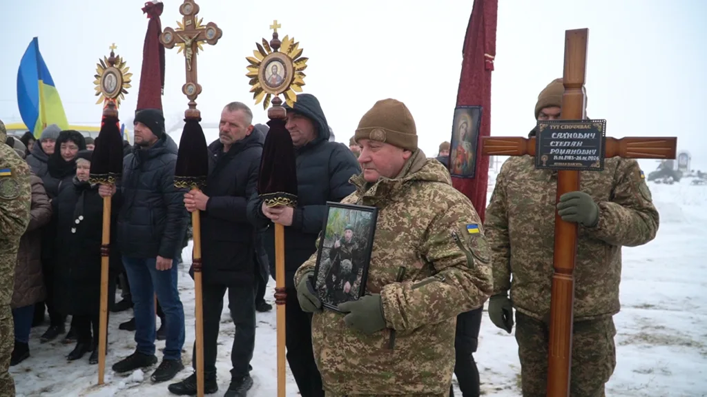 Військові несуть портрет і хрест на похороні