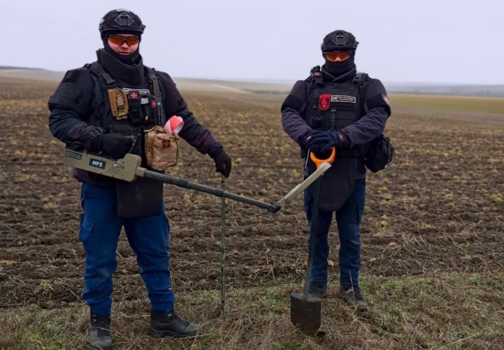 Сапери працюють на полі з металошукачем