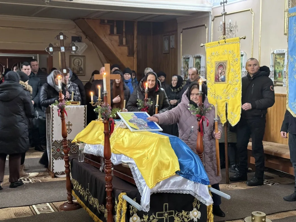 Похоронна церемонія у церкві з українським прапором