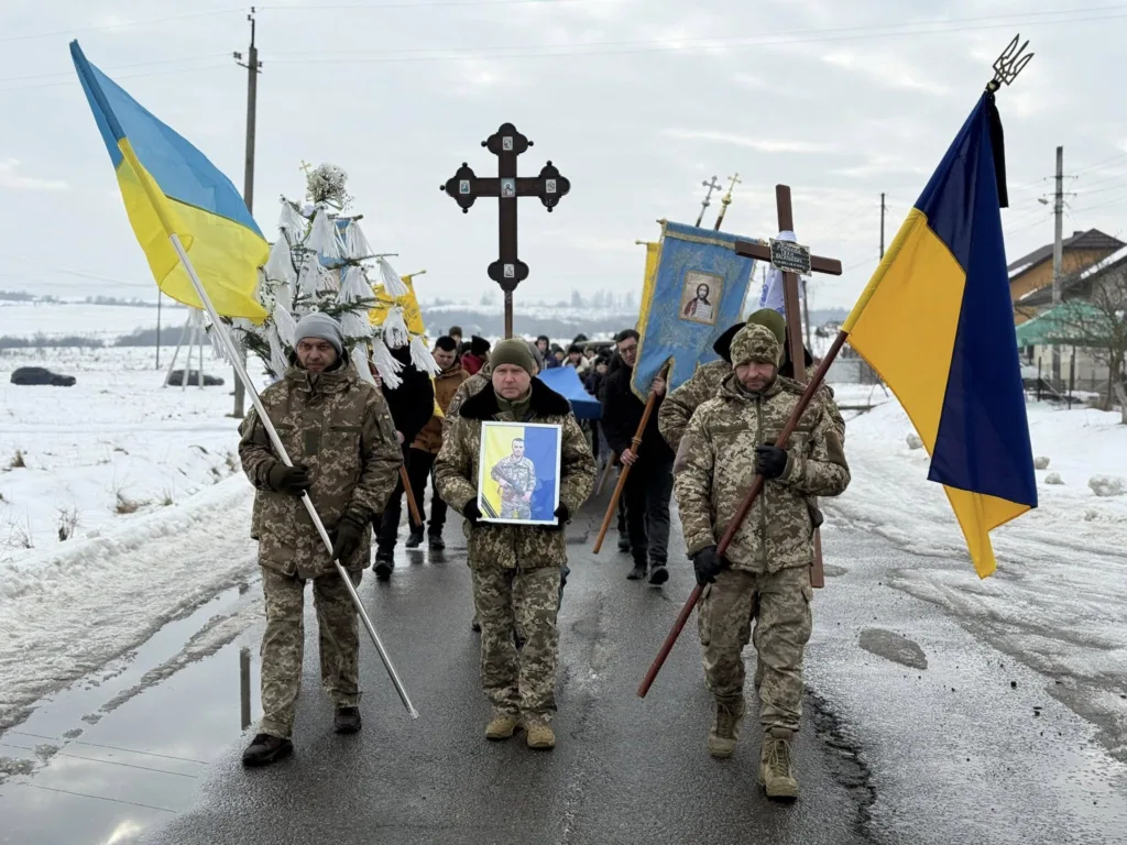 Українські військові несуть прапори під час церемонії