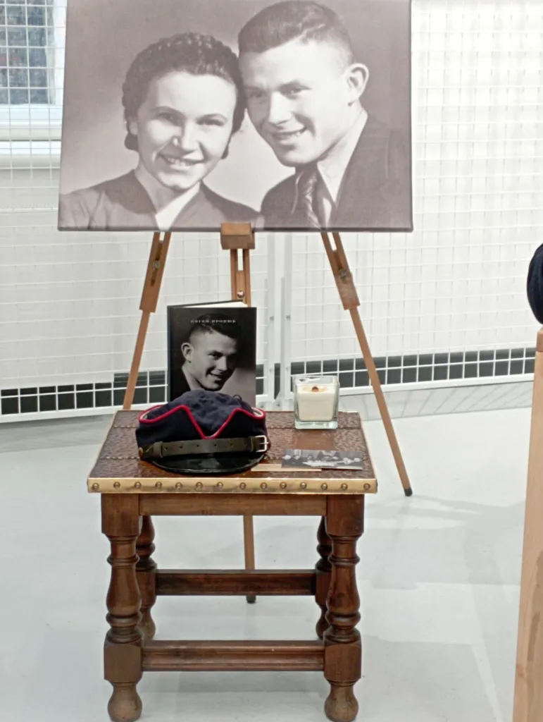 Старе фото пари над столом з капелюхом і свічкою