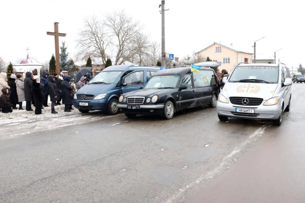 Похоронна процесія в зимовий день біля церкви
