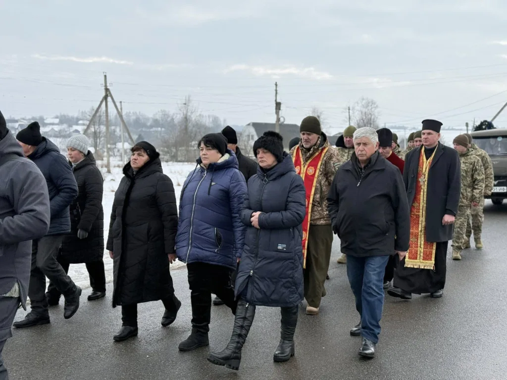 Люди йдуть зимовою дорогою під час церемонії