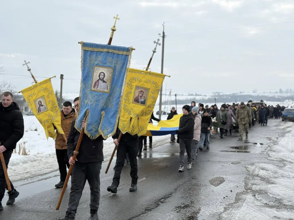 Похоронна процесія з українськими прапорами та іконами