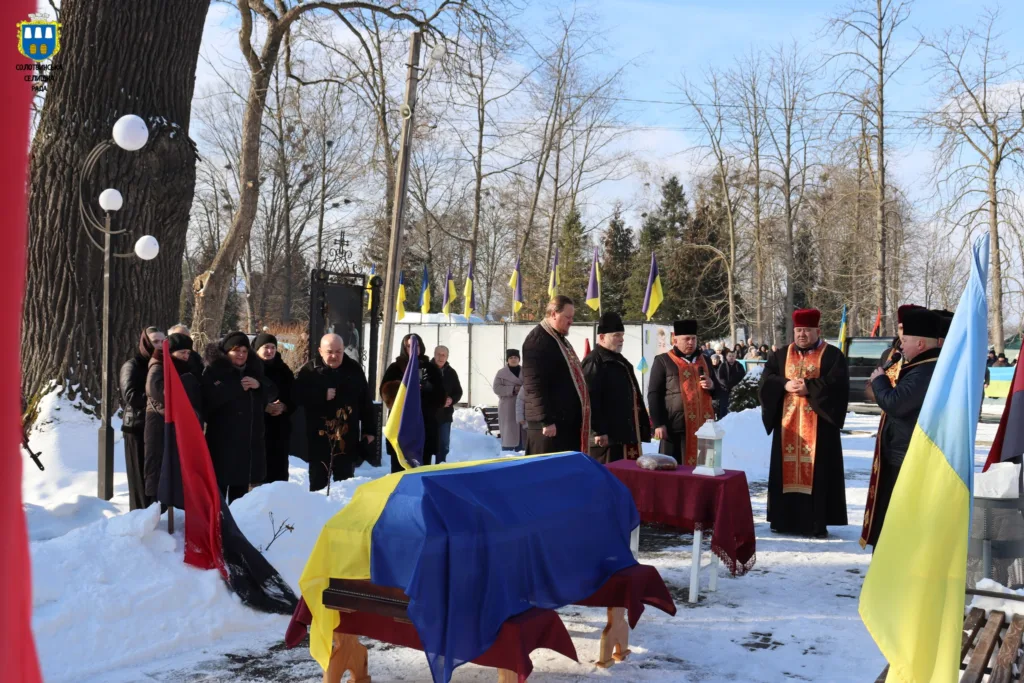 Похоронна церемонія з українськими прапорами взимку