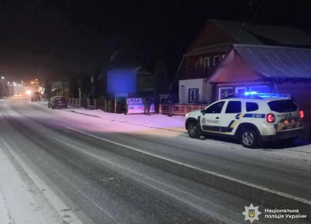 Поліцейська машина на засніженій дорозі вночі