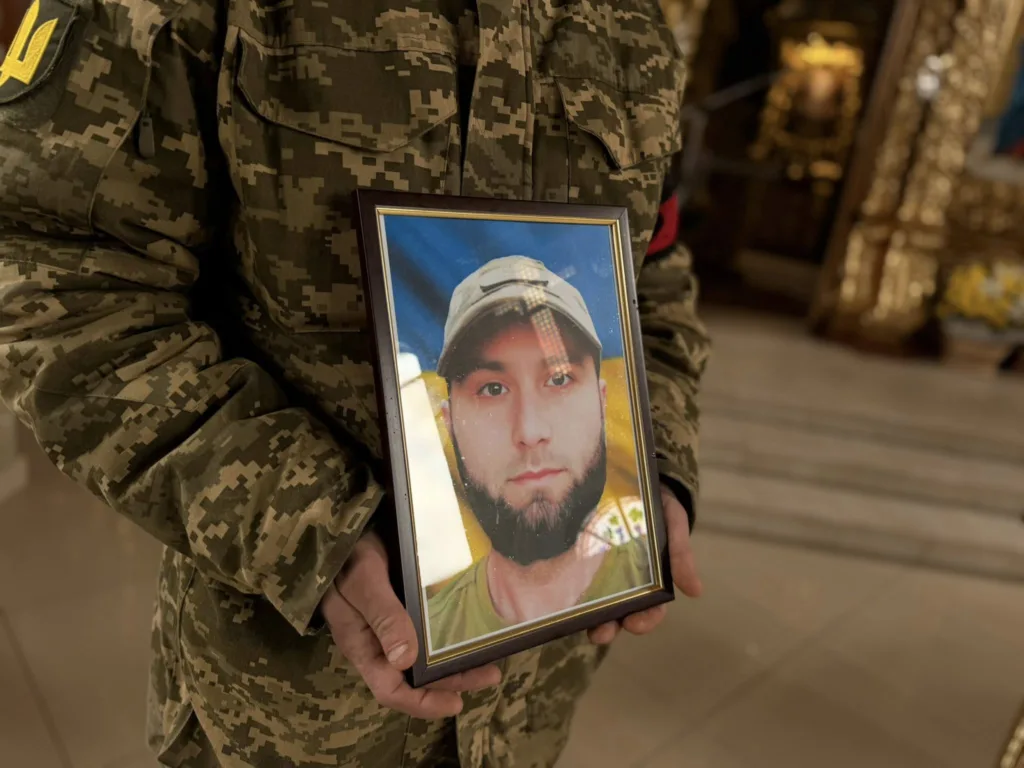 Військовий тримає портрет загиблого солдата