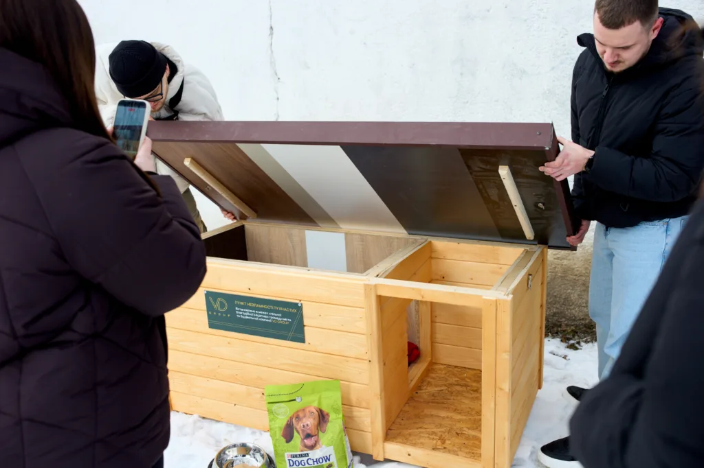 Люди встановлюють дерев’яний будиночок для безпритульних тварин