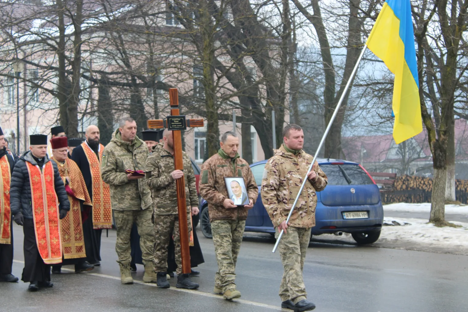 Військові несуть прапор і хрест на церемонії