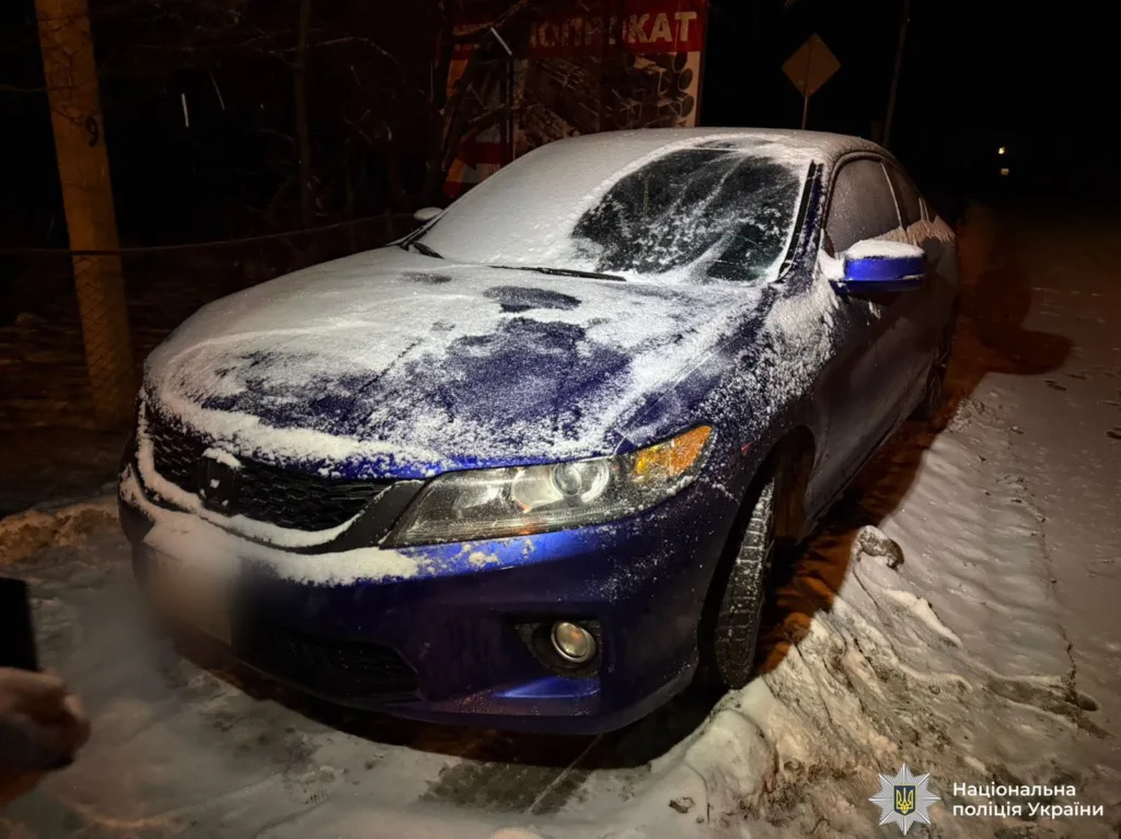 Синій автомобіль, вкритий снігом на дорозі