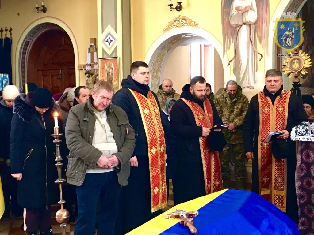 Священники і люди на похороні у церкві