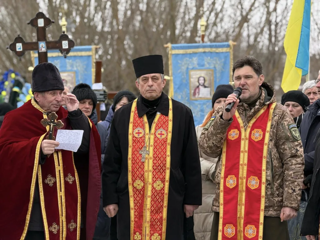 Священники проводять молебень на вулиці з прапором України
