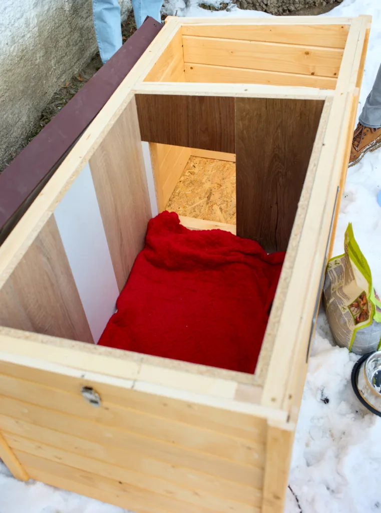 Дерев'яна будка з червоною ковдрою всередині