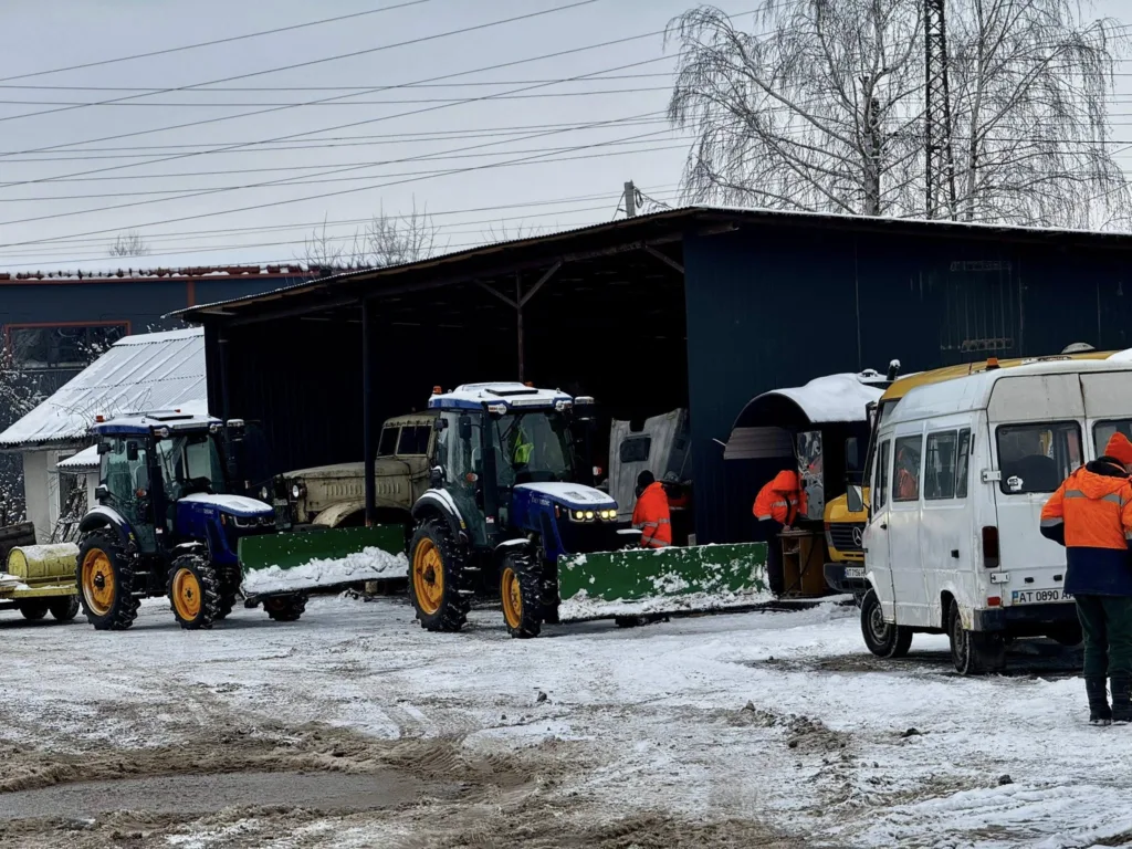 Трактори прибирають сніг біля гаража взимку
