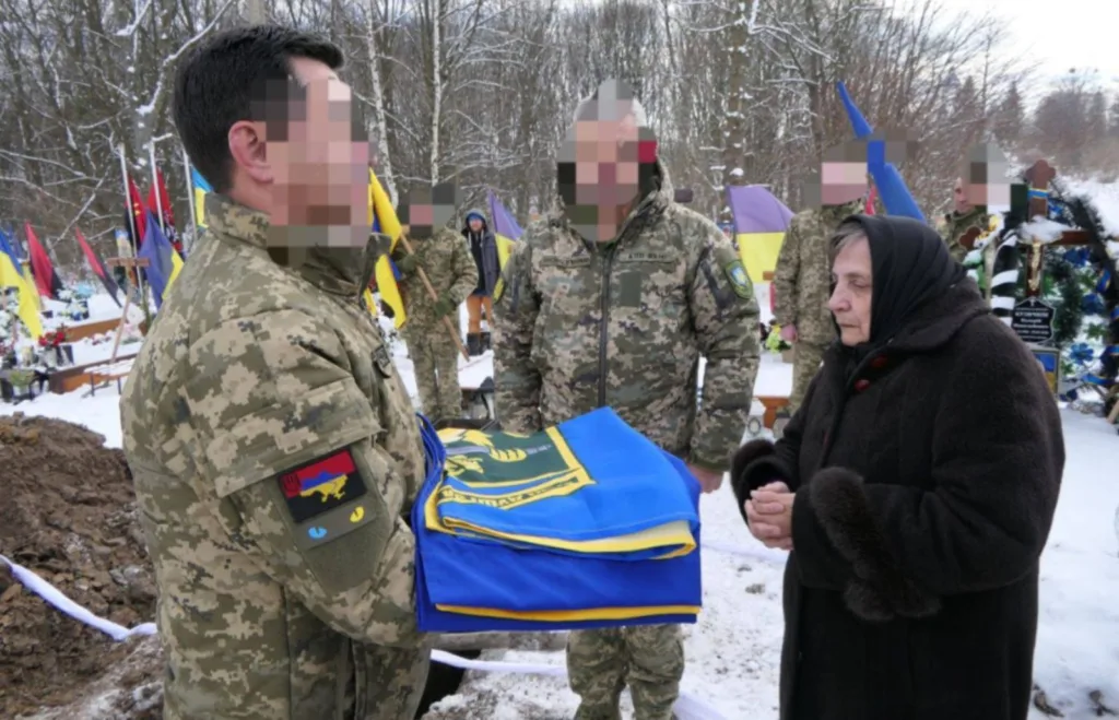 Військові передають прапор жінці на цвинтарі