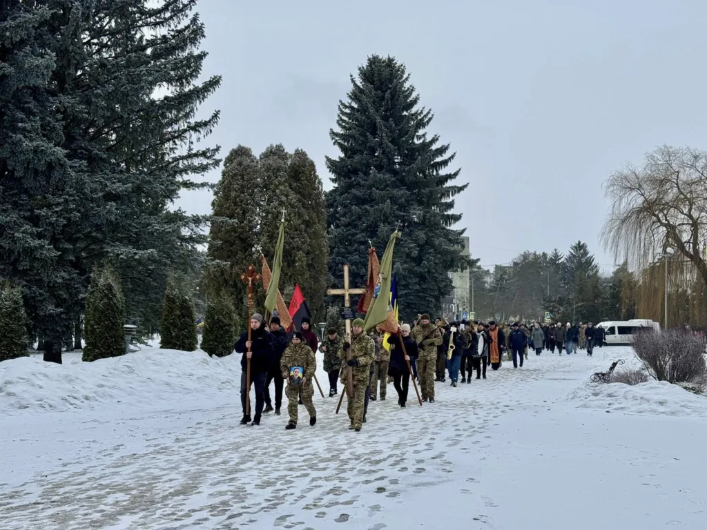 Зимова похоронна процесія з прапорами в Україні