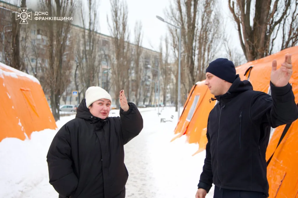 Рятувальники спілкуються біля помаранчевих наметів узимку