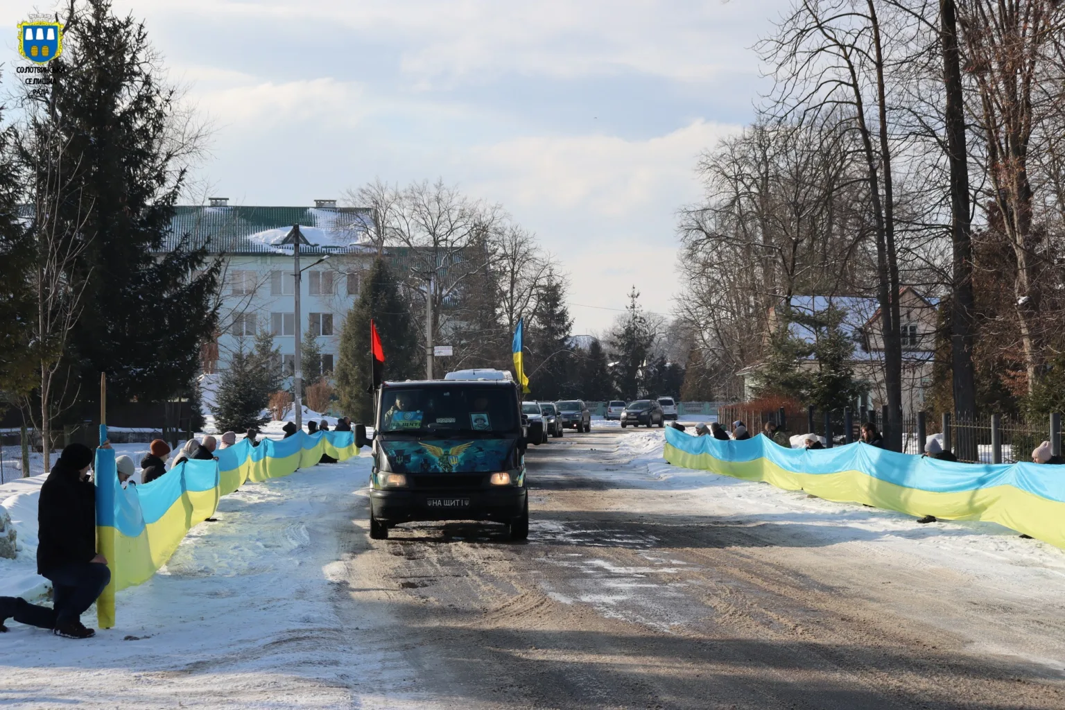 Автоколона з українськими прапорами на зимовій вулиці