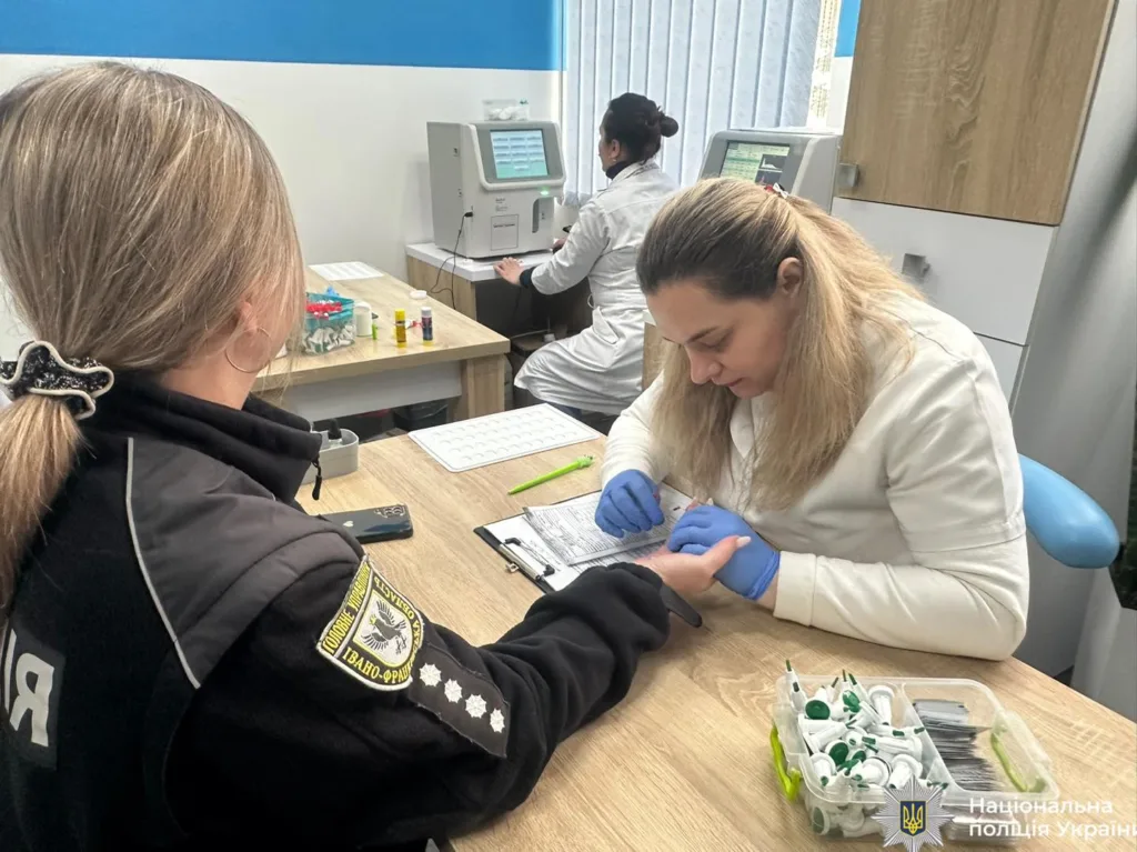 Поліцейська здає відбитки пальців у лабораторії