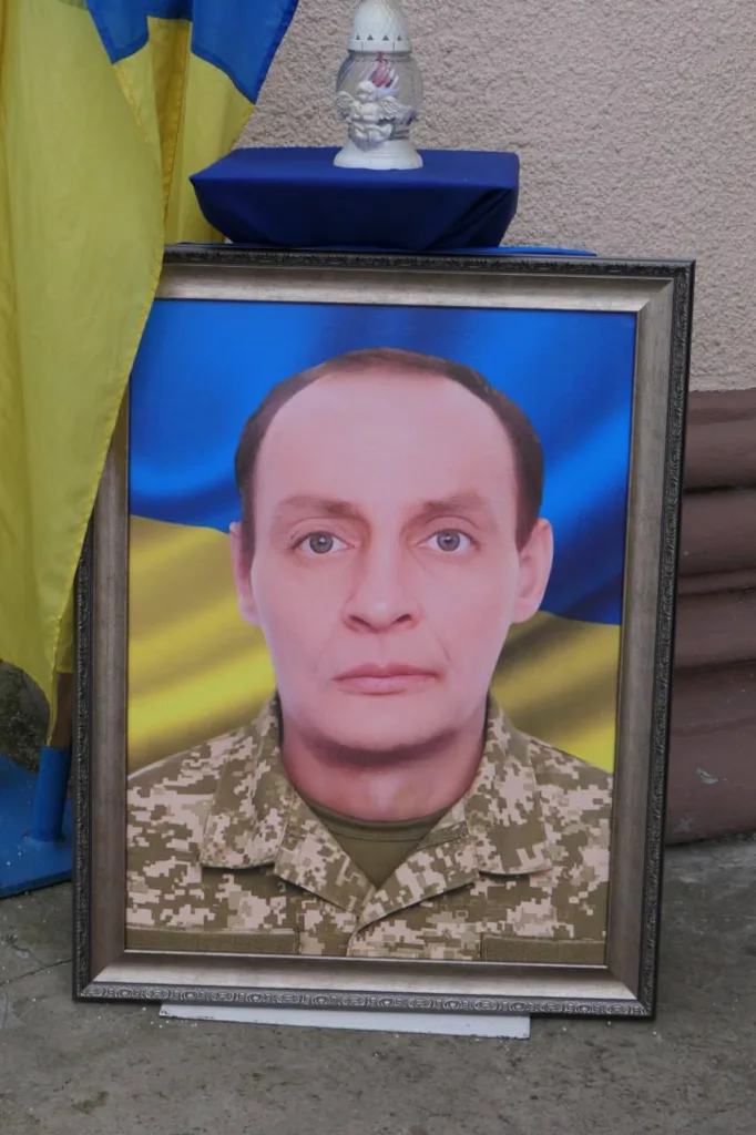 Портрет військового перед українським прапором