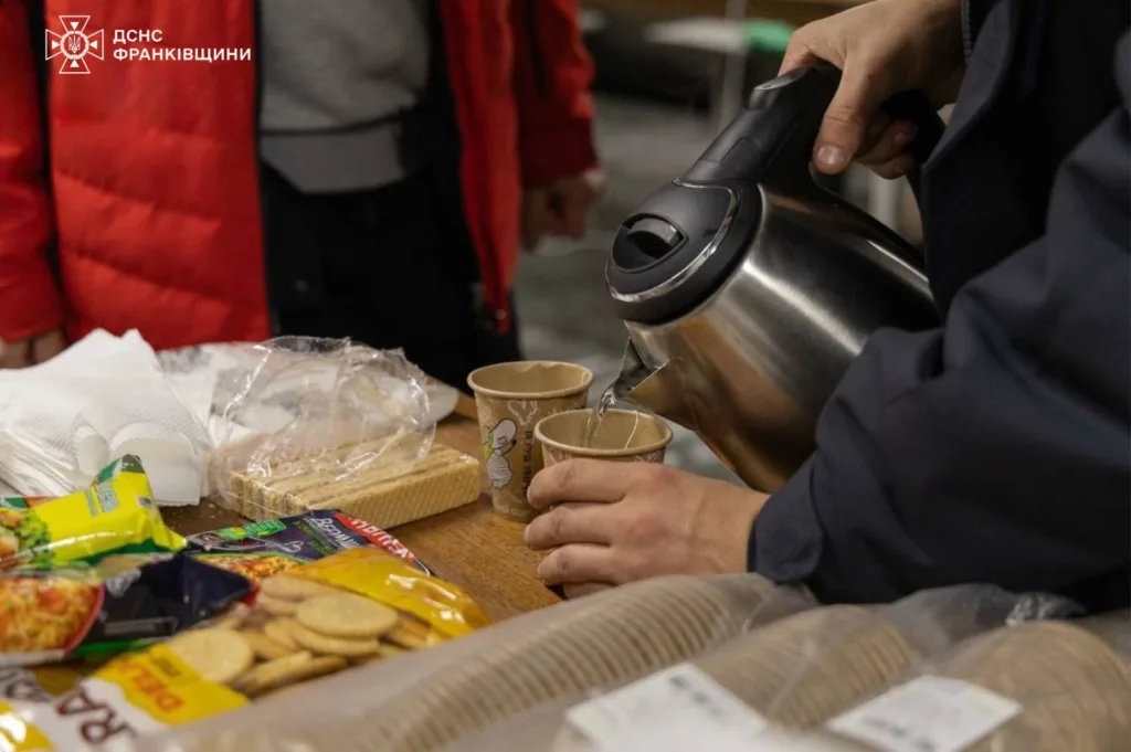 Людина наливає гарячу воду у паперові стакани.