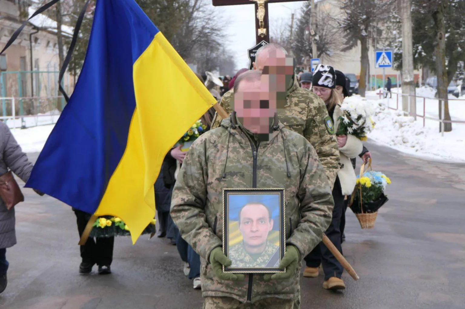 Процесія з українським прапором та портретом військового