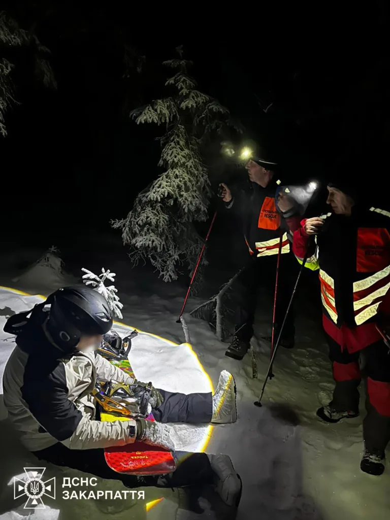 Рятувальники допомагають snowboardеру в горах вночі