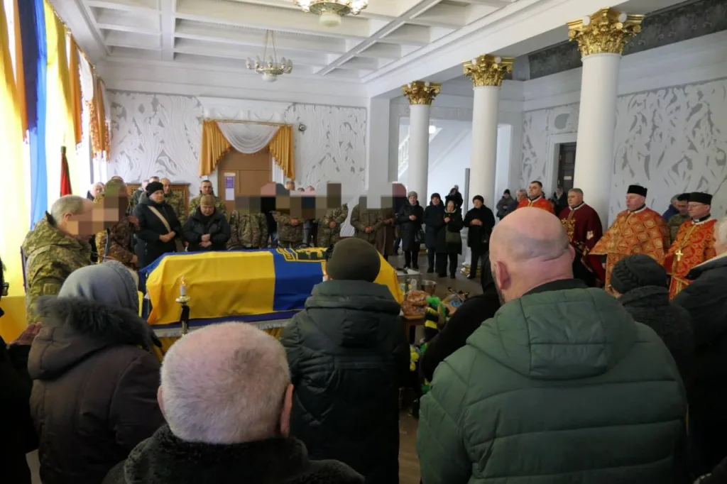 Прощання із військовим, накритим українським прапором