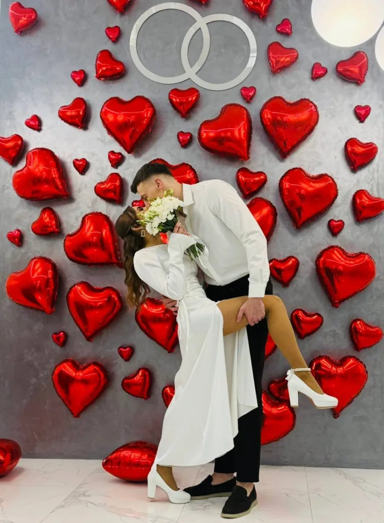 Закохана пара на тлі червоних сердечок