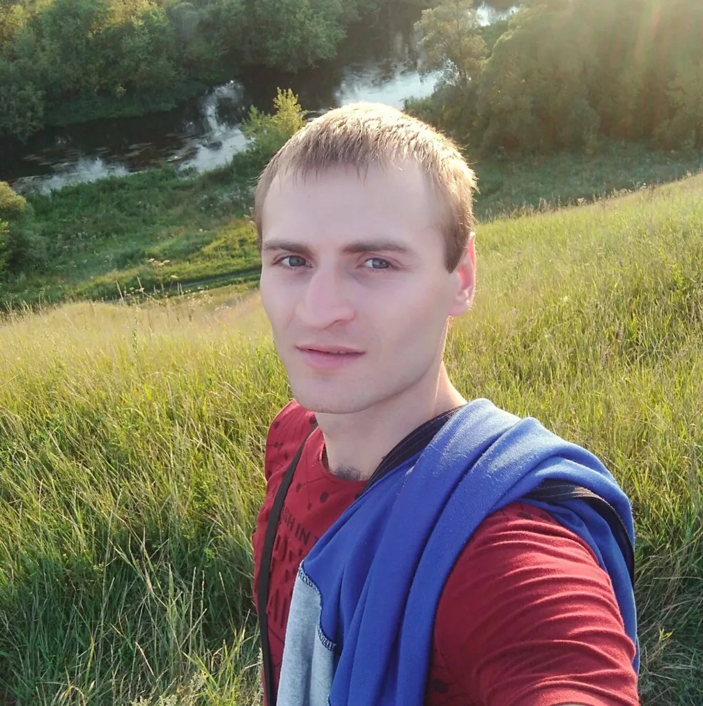 Чоловік робить селфі на зеленому пагорбі біля річки