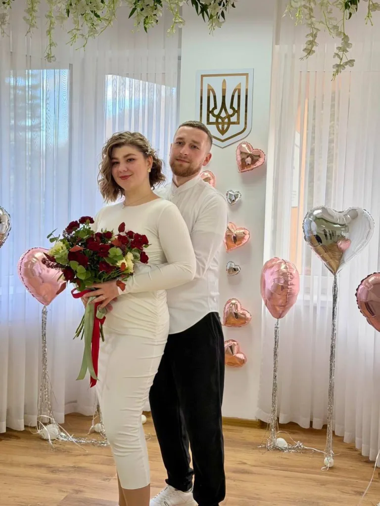 Пара святкує весілля з букетом та кульками сердець