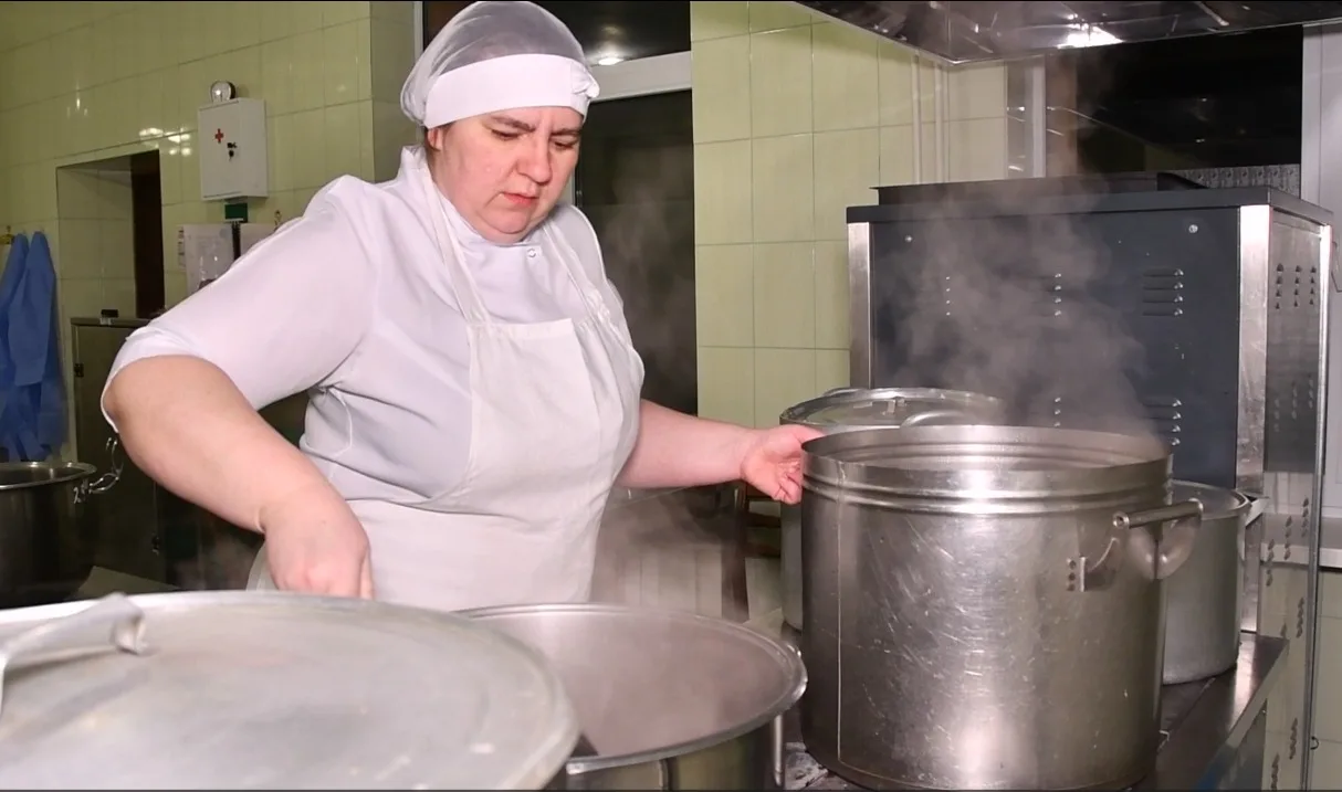 Кухар готує їжу на великій кухні