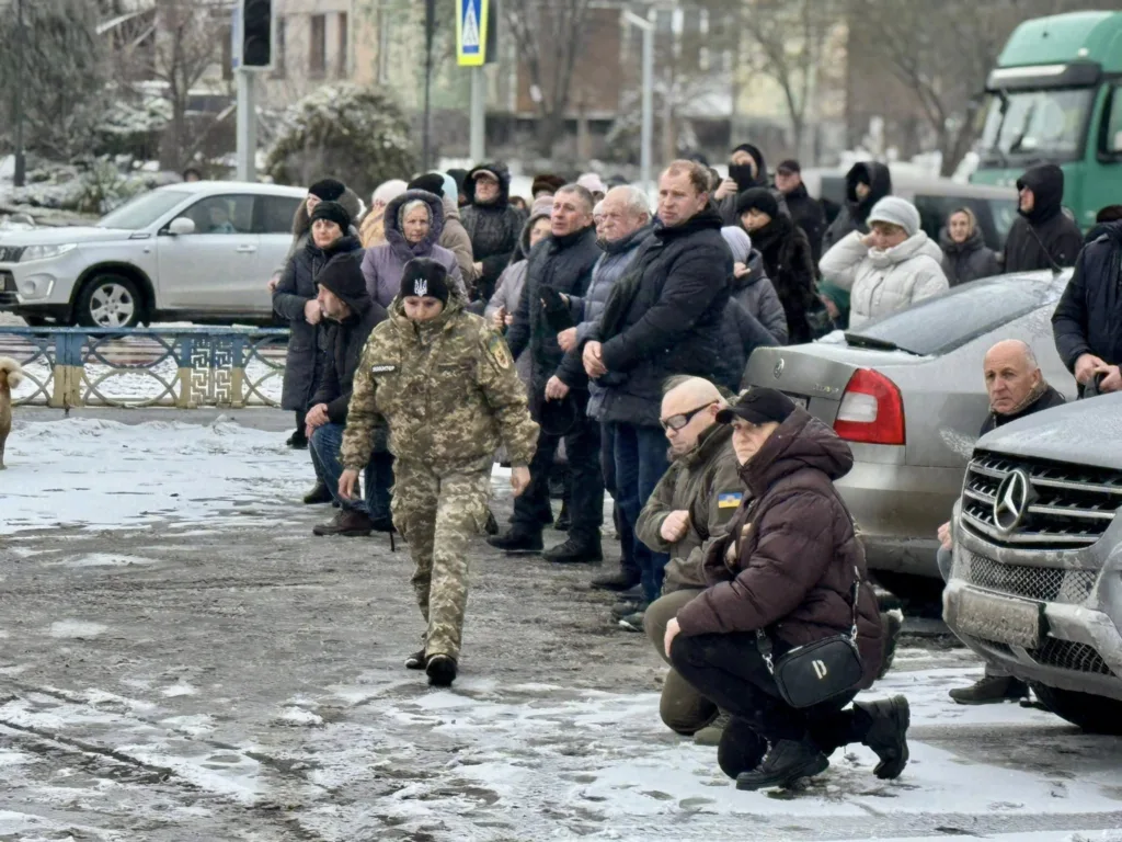 Люди на вулиці вшановують українського військового