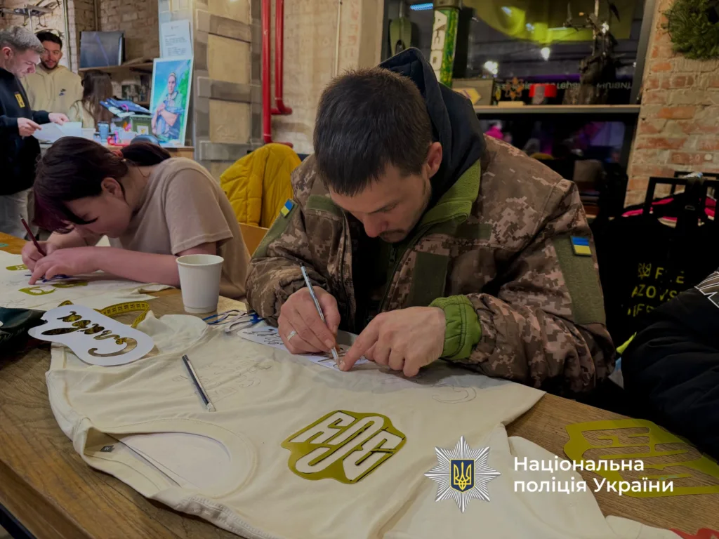 Люди малюють патріотичні написи на футболках