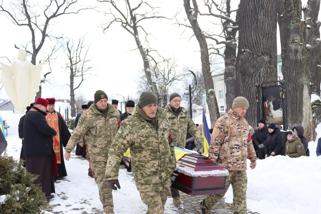 Військові несуть труну на зимовій церемонії похорону