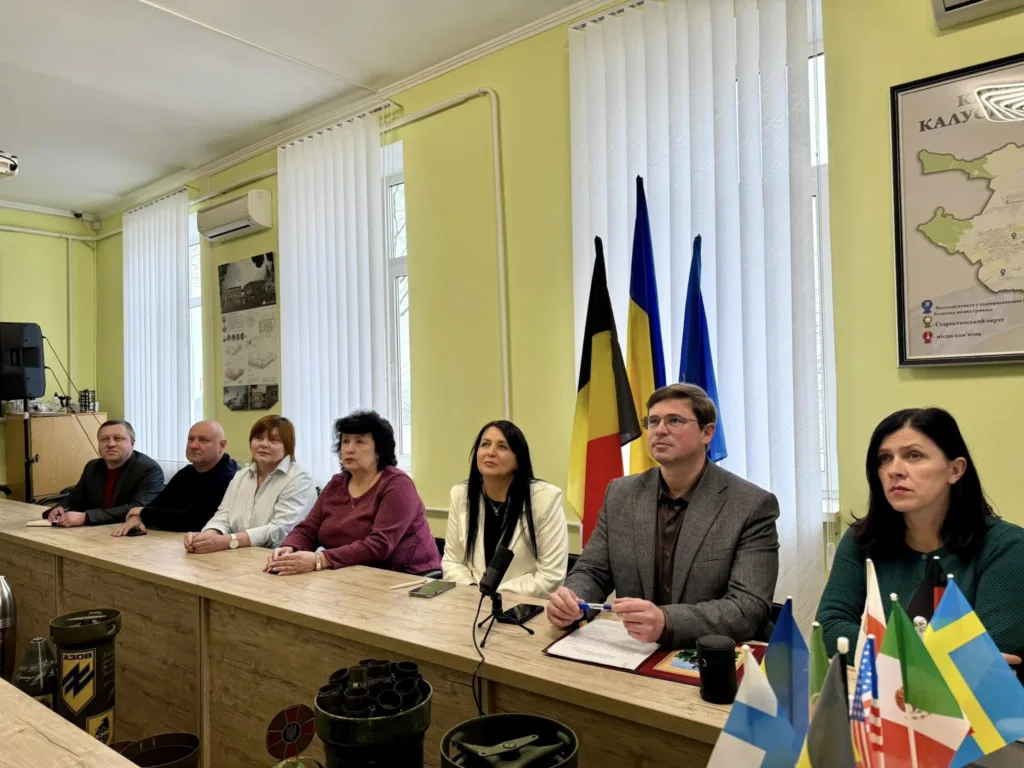 Люди на нараді з міжнародними прапорами на столі