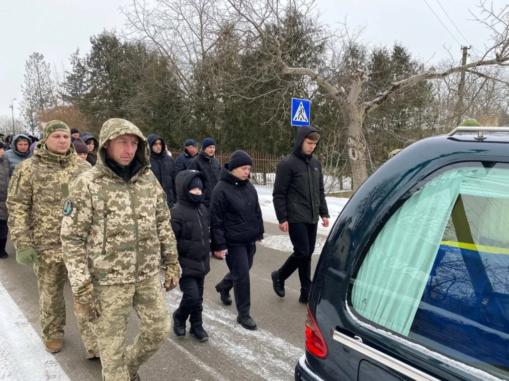 Похоронна процесія з військовими та людьми взимку